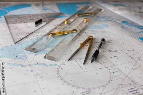 Maps of the ship for plotting. Plotter, divider, ruler and pen. Close-up.