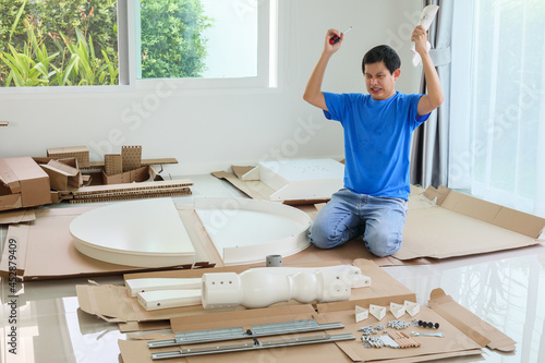 Man assembling white round table furniture at home