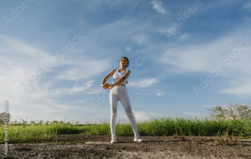 Beautiful Asian young woman stretching exercises outdoor. Healthy women concept.