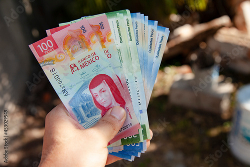 hand of a man holding new bank notes of mexican peso