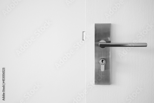 Modern door handle with keyhole on white door