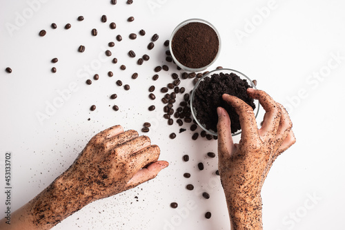 Young woman hand applying pick coffee grounds scrub massaging cosmetic skincare. Scrub exfoliates old skin cells.