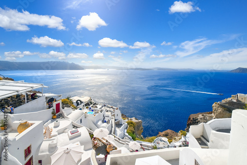 The whitewashed hillside town of Oia, Greece, filled with cafes and hotels overlooking the Aegean Sea and Caldera.