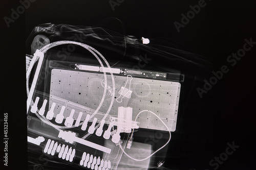 Xray image of a wrenches set, an electrical device with dry cell batteries, and some cables.
