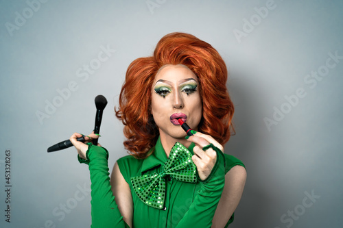 Happy drag queen having fun while doing makeup in studio