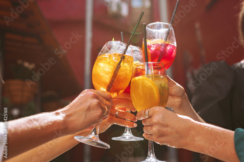 A group of friends cheers their drinks together, celebrating birthday.