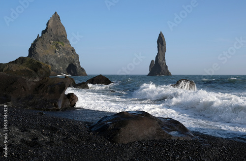 Waves coming in at Reynisfjara Black Beach, Iceland, with rock formations in the background
