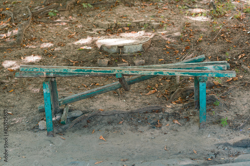 Green broken bench outdoor. Street. Park. Vandals. Wooden. Ground. Damage. Damaged