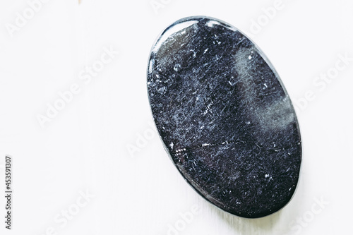 Galet pierre roulée polie tourmaline noire sur un fond blanc - Minéral naturel