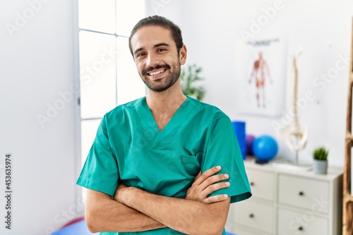 Young physiotherapist working at pain recovery clinic happy face smiling with crossed arms looking at the camera. positive person.