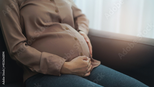 depressed pregnant woman touching her belly