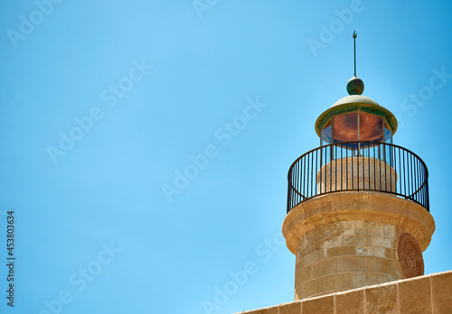 Sea lighthouse with lightning rod in cloudless sky