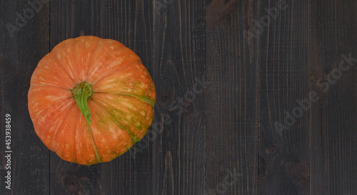 Wooden background composed with a pumpkin. Halloween or harvest concept. Happy Thanksgiving Day.