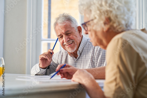 Couple of seniors has fun solving puzzles as memory training