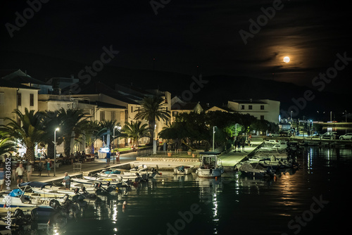 Nabrzeże portowe wieczorową porą oświetlone księżycem na wyspie Pag, Chorwacja