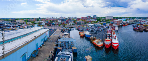 New Bedford harbor panorama aerial view with fishing boats docked at piers and historic downtown of New Bedford at the background, Massachusetts MA, USA. 