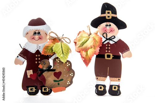 Wooden pilgrim man and woman figurines for Thanksgiving holiday agaist white background