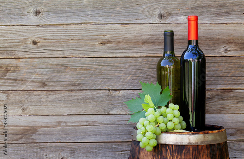 Grapes and wine bottles on wine barrel