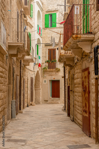 włoski flagi na balkonach na wąskiej uliczce w miejscowości Molfetta w Puglia