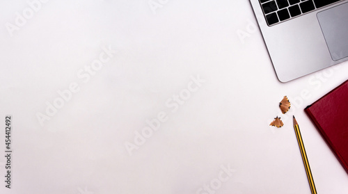 Laptop with notebook and pencil on white background. Office concept. Top view. Flat lay. Copy space.