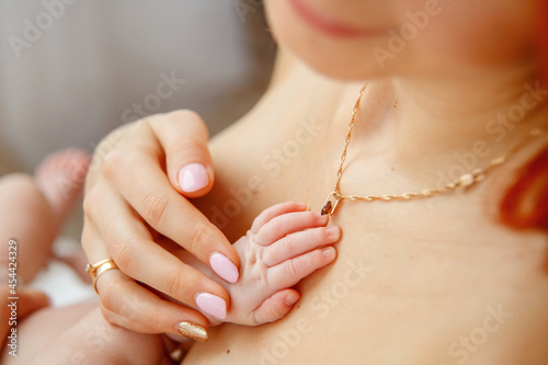 Baby touching mother's hand . Newborn baby hand in mother hand. Help asistance concept 