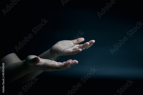 Symbol by hand. supplication and faith, intercession, encouragement gesture of male hands on black background with copy space