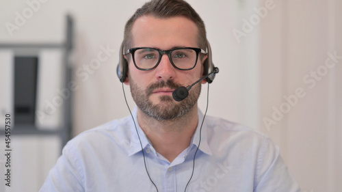 Portrait of Middle Aged Man with Headset Looking at the Camera 