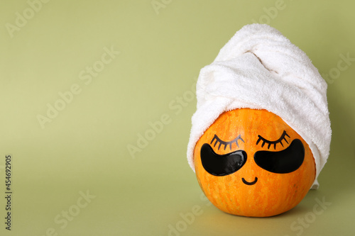 Spa concept with pumpkin on green background