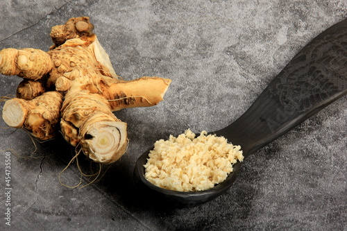 Fresh grated Horseradish roots on wooden table. The root of horseradish