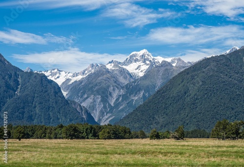 Alpine landscape with forests and snowy mountains on the South Island of New Zealand on sunny day