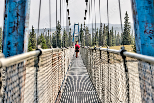 Mother and son hiking along a bridge crossing the South Saskatchewan River in the Nordegg Region of the Canadian Rocky Mountains