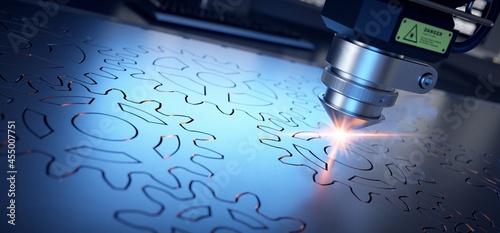 Laser cutter close up, cutting gears in a steel sheet. 