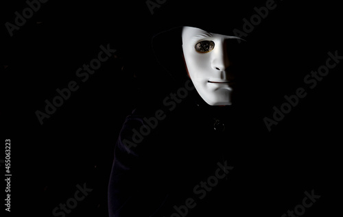 Anonymous careta blanca ojo con moneda de bitcoin con capucha y fondo negro. Hombre Anonymous careta blanca y moneda de bitcoin en lugar del ojo con capucha y fondo negro.