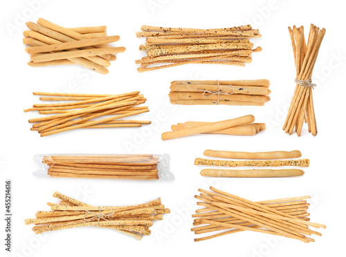 Set with delicious crispy grissini sticks on white background