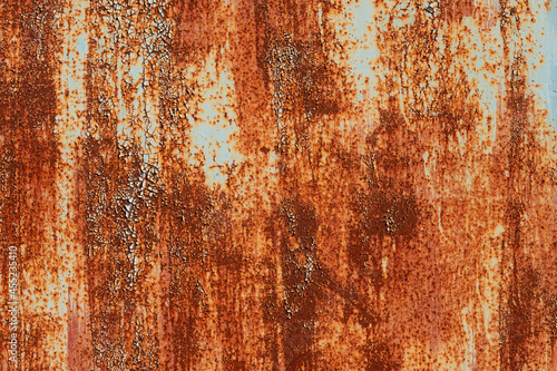Old metal surface covered with paint through which rust appears. Smudges texture with elements of corrosion