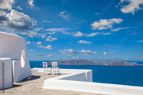 Santorini island caldera view with chairs and white architecture, romantic mood, couple travel vacation landscape destination scenic. Tourism view, amazing sky sea Greece mood. Summer romance holiday