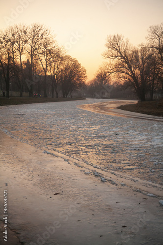 Pokryta całkowicie lodem rzeka w zachodzącym zimowym słońcu