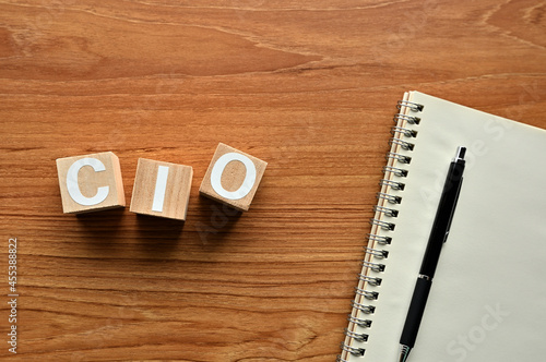On a wood board, wooden word cubes are arranged in the letters CIO. It is an abbreviation for chief information officer.