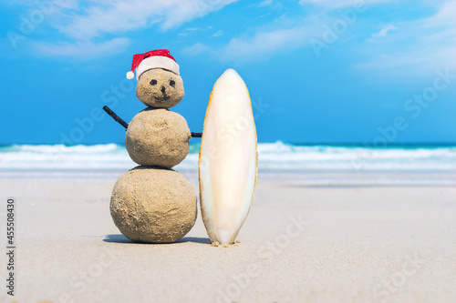 joyful Sandman of white sand on the clean beach of an exotic island on the background of blue sea and cloudy sky.