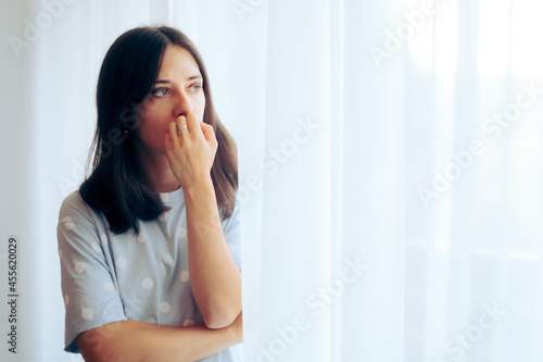 Depressed Woman Feeling Sad Standing by the Window