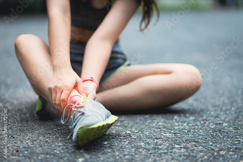 The female athlete suffered an ankle injury. A female runner has pain in her ankle.