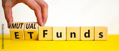 Mutual funds vs ETF symbol. Businessman turns cubes and changes words 'ETF, Exchange-Traded Fund' to 'Mutual funds. Beautiful white background, copy space. Business and ETF vs mutual funds concept.