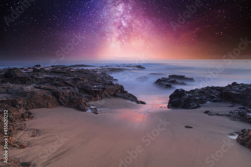 Milky way shimmers over the ocean water