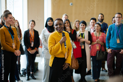 Smiling female speaker with microphone on stage