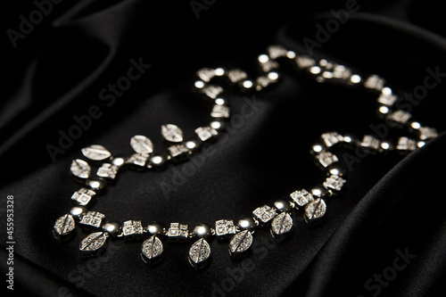 Necklace with diamonds on black background with copy space