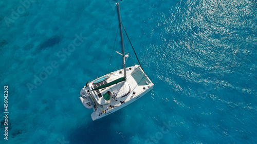 Aerial drone photo of beautiful catamaran sailing yacht anchored in tropical exotic turquoise sea exotic bay