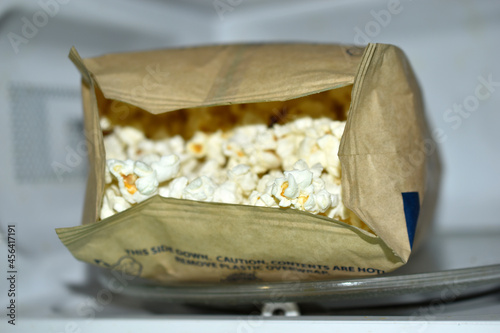 A bag of popcorn in the microwave to cook
