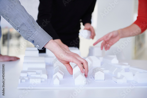 Colleagues in architect office with architectural model