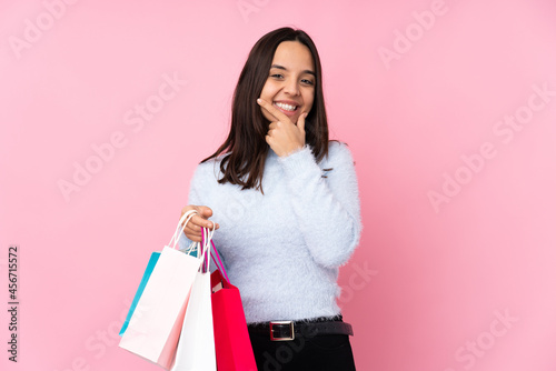 Young woman with shopping bag over isolated pink background smiling