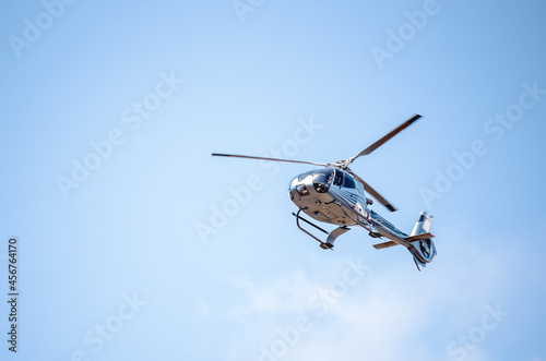 Flying helicopter in blue sunny sky